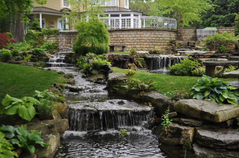 paysagiste-GARS-min_landscaping-rock-louisville-ky-traditional-landscape-and-boulders-brick-wall-bushes-grass-koi-law